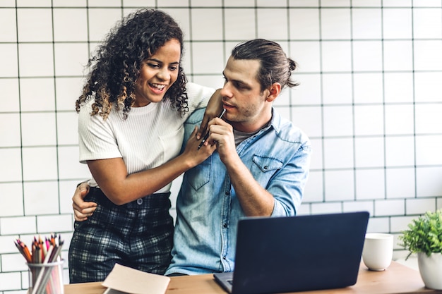 Feliz pareja sonriente trabajando juntos en la computadora portátil