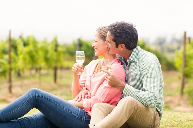 Foto feliz pareja sosteniendo copas de vino y mirando la naturaleza