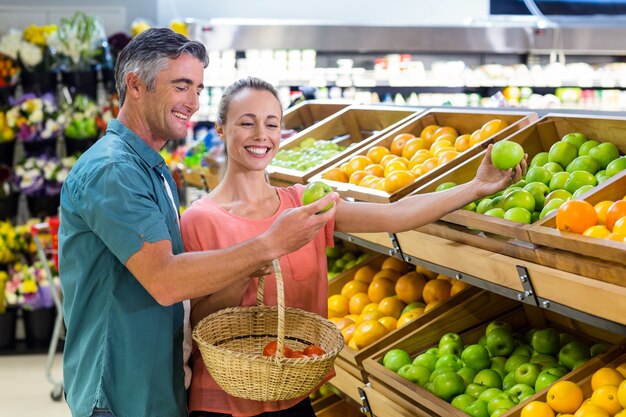 Feliz pareja sosteniendo una manzana