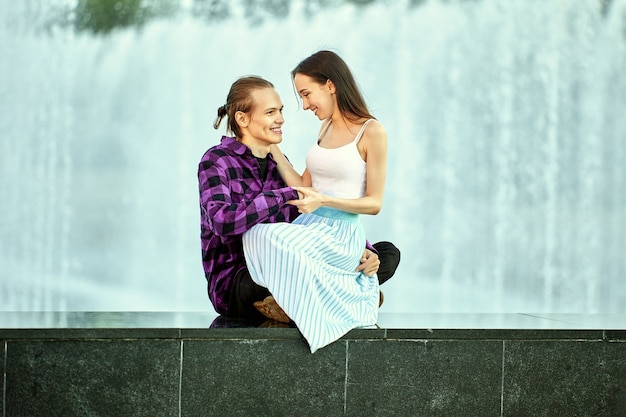 Feliz pareja tiene cita junto a la fuente en el parque