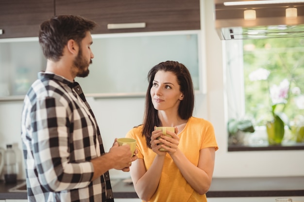 Feliz pareja tomando un café en la cocina