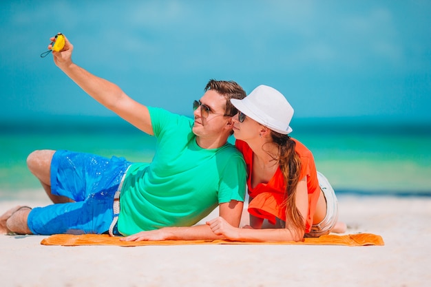 Feliz pareja tomando una foto en una playa de vacaciones