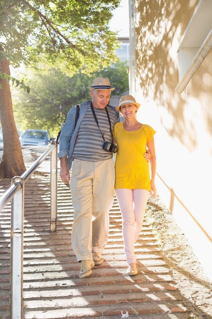 Feliz pareja de turistas caminando en la ciudad