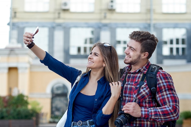 Feliz pareja de turistas tomando selfie en showplace de ciudad