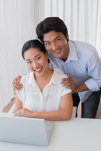 Feliz pareja usando laptop juntos