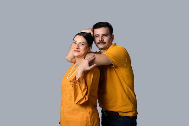 Feliz pareja vistiendo camisetas amarillas pose frontal modelo paquistaní indio