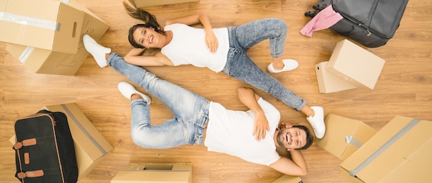 Foto la feliz pareja yacía en la vista del piso de parquet desde arriba