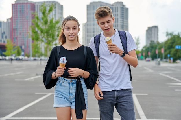 Feliz parlante de adolescentes caminando juntos en la ciudad