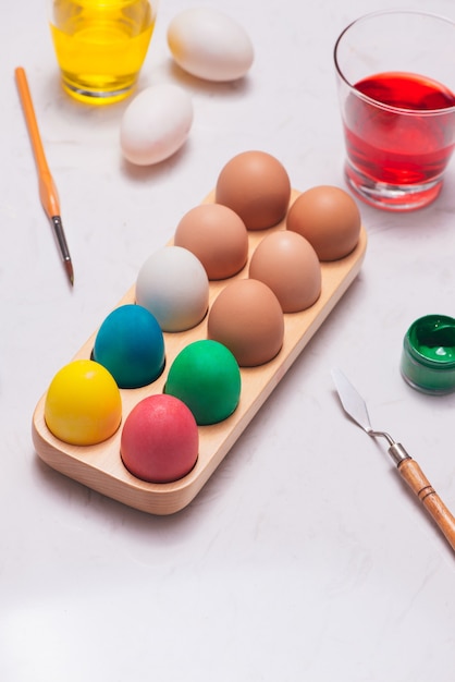 Feliz Páscoa! Amigos pintando ovos de Páscoa na mesa.