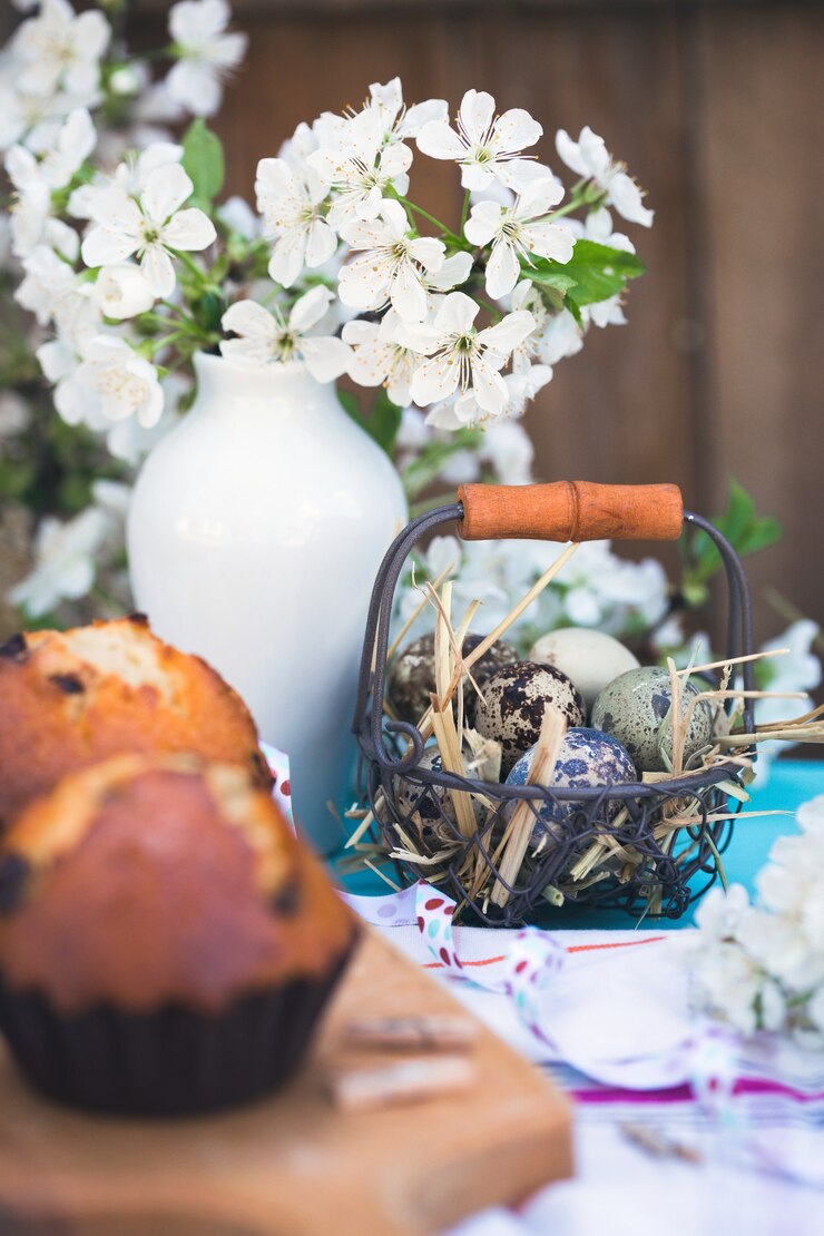 Foto feliz páscoa - cesta de ovos e cupcakes no fundo de flores de cerejeira