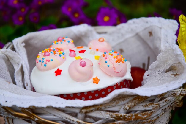 Feliz Páscoa Cesta de Páscoa com um bolo com glacê branco e merengue rosa