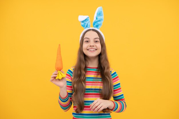 feliz páscoa criança em orelhas de coelho segura cenoura para férias, coelhinho da páscoa.