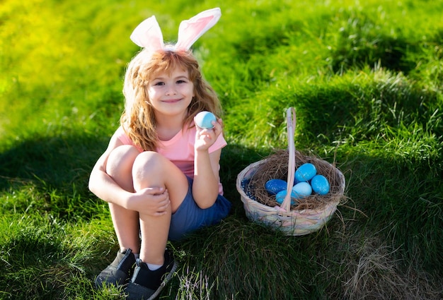 Feliz páscoa crianças em orelhas de coelho com ovo de páscoa na cesta menino brincam de caçar ovos