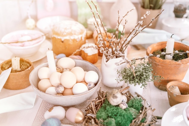 Feliz páscoa e feriados de primavera tempo festivo tablescape decoração tradicional jantar comida ovos de páscoa e bolos assados na mesa em casa coelho e salgueiro pálido pop pastel azul e rosa clarão