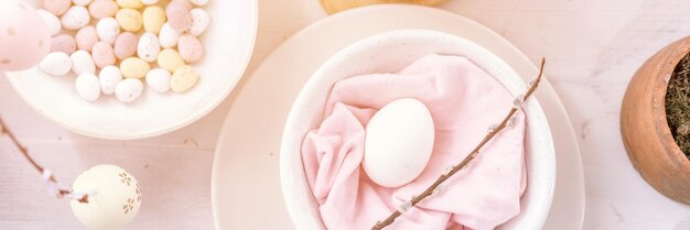 Feliz páscoa e feriados de primavera tempo festivo tablescape decoração tradicional jantar comida ovos de páscoa e bolos assados na mesa em casa pop pálido azul pastel e cor rosa vista superior banner flare