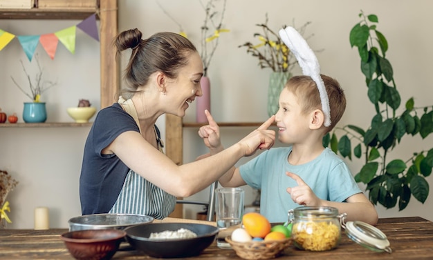 Foto feliz páscoa mãe e filho estão se preparando para a páscoa da primavera colorindo alegremente ovos de férias.