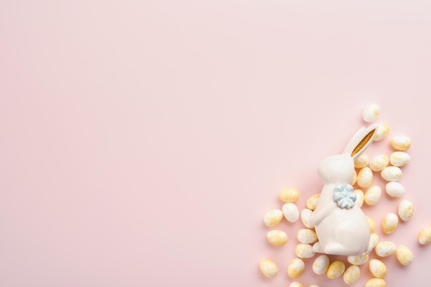 Feliz Páscoa Ovos de Páscoa e decoração de coelho branco isolados em fundo rosa pastel da moda com rosas brancas e amarelas Primavera Cartão de feliz Páscoa e simulação de fundo Vista superior plana