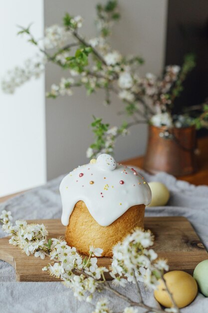 Feliz Páscoa Pão de páscoa caseiro ovos tingidos naturais e flor de primavera em mesa rústica na sala