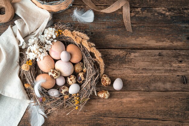 Feliz Pascua, fondo festivo con huevos en un nido sobre un fondo de madera.