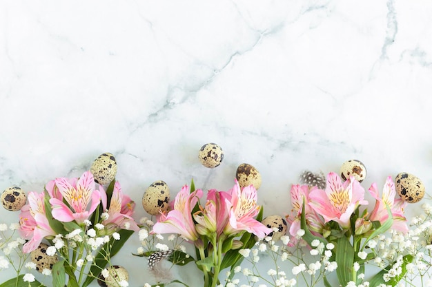 Foto feliz pascua huevos de codorniz plumas primavera flores rosas sobre fondo de mármol