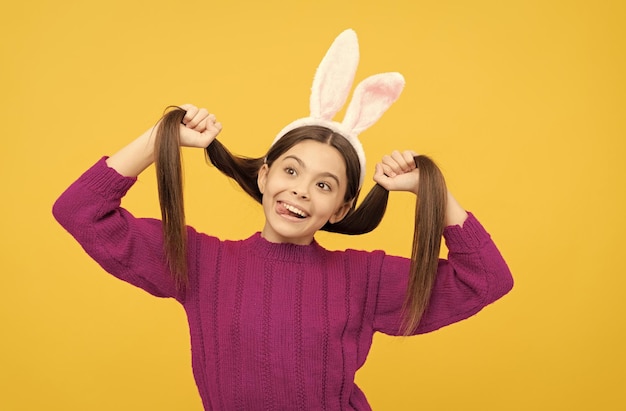 Feliz pascua jovencita en divertidas orejas de conejo divirtiéndose felices pascuas