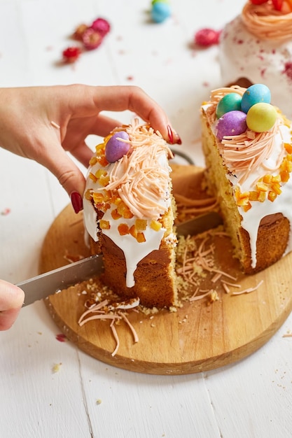 Feliz Pascua Mujer cortó el pastel de Pascua para las vacaciones El concepto de preparación para las vacaciones de Pascua