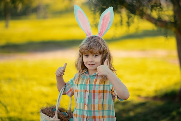 Feliz pascua niño niño cazando huevos de pascua lindo niño disfrazado de conejo con orejas de conejo con pascua