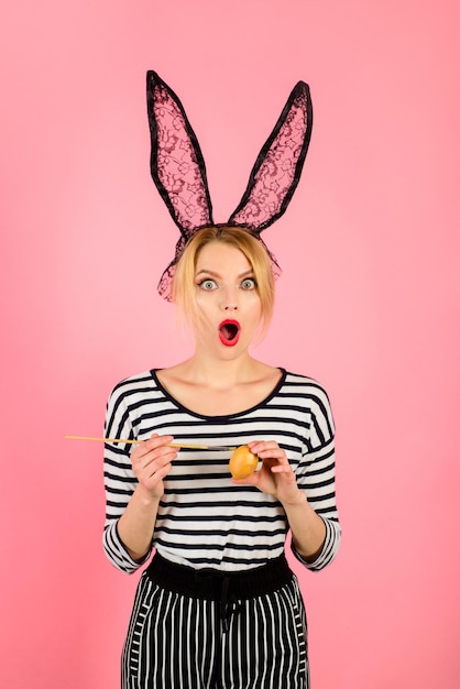 Feliz Pascua pintura huevo concepto de pascua el día de pascua conejo blanco traje de conejito mujer sorprendida en