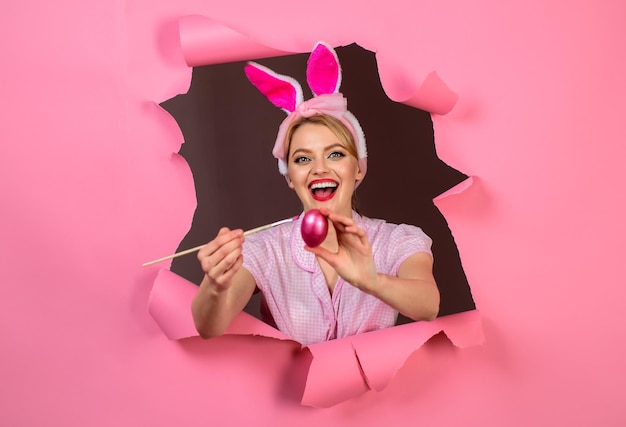 Feliz pascua a través de la búsqueda de papel para huevos de pascua mujer con orejas de conejo falsas mujer feliz pintura