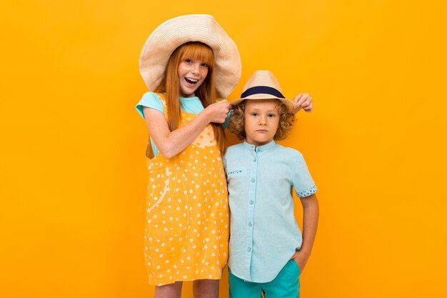 Feliz pelirrojo niño y niña en sombreros de verano