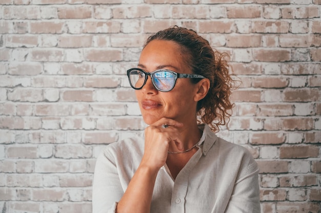 Feliz y pensativa mujer de negocios milenaria mirando casualmente a la ventana con una sonrisa pensativa y soñadora pensando en el proyecto de trabajo visión futura ambiciosos objetivos de planificación de carrera Head shot portraitxA