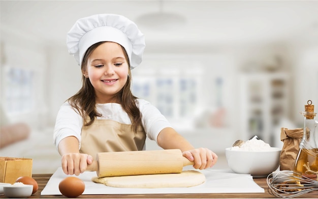 Feliz pequeno chef manchado com farinha de alongamento