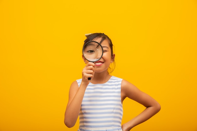 Foto feliz pequeño niño asiático con lupa