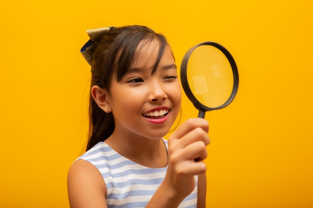 feliz pequeño niño asiático con lupa