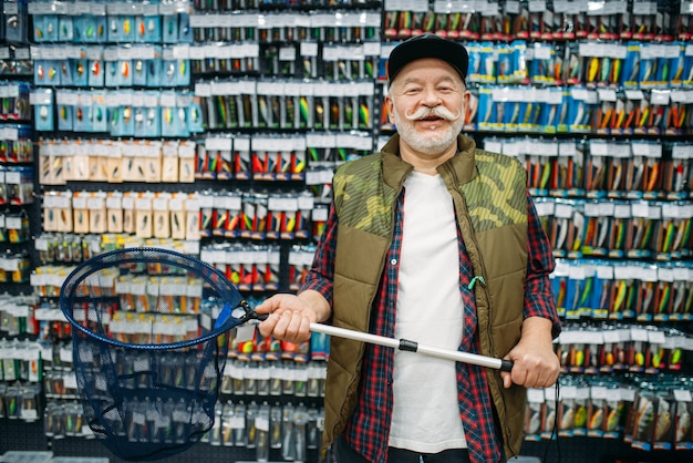 Feliz pescador tiene net en tienda de pesca