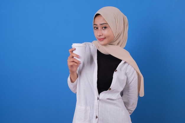 Feliz por uma jovem com camisa branca e véu segurando a xícara de café