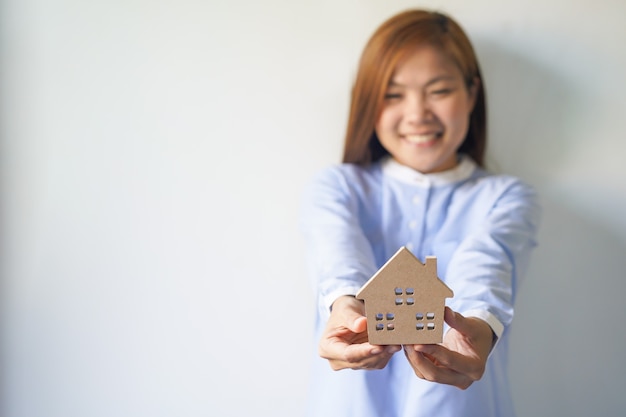 Foto feliz propietario nuevo con modelo de casa en sus manos