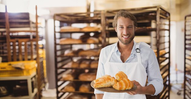 Feliz propietario de una pequeña empresa con croissants