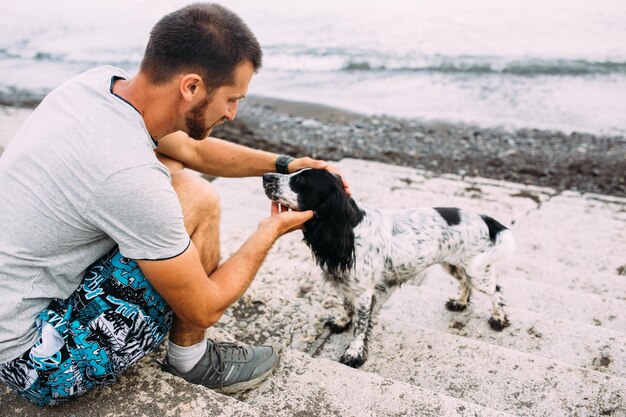 Feliz propietario de la responsabilidad del perro cocker spaniel ruso de cuidar a la mascota