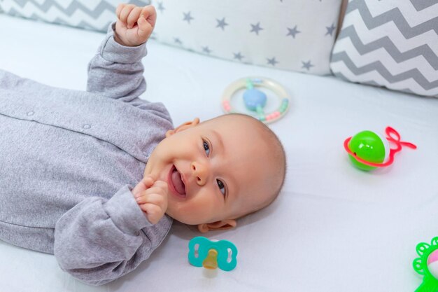 Feliz recién nacido en la cuna se ríe adorable