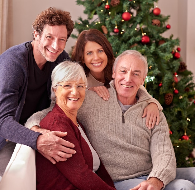 Feliz retrato de família e avós em casa para o Natal para comemorar junto com a filha e o filho Pais idosos, homens e mulheres, adoram passar bons momentos ou se relacionar no sofá nas férias de inverno
