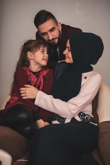 Foto feliz retrato familiar musulmán padres sonrientes y su linda hijita posando juntos