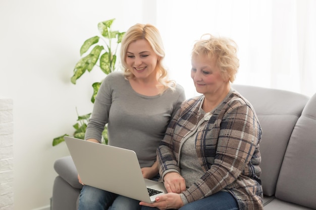 Feliz retrato de primer plano de madre e hija adulta en casa