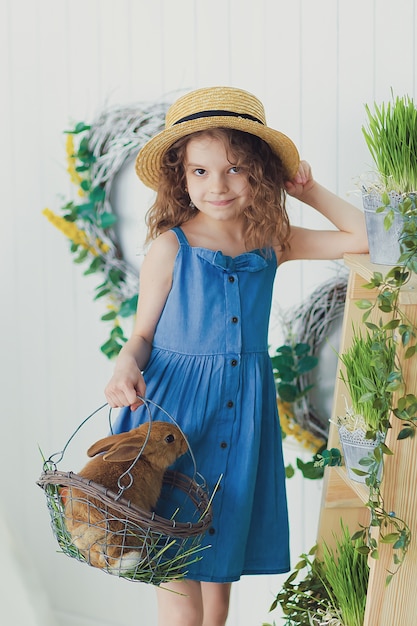 Feliz rindo menina brincando com um coelho bebê