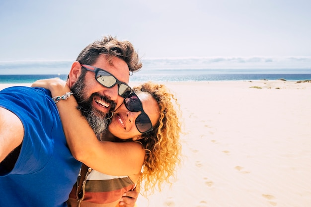 Foto feliz y saludable pareja de personas disfrutando de su vida y sus vacaciones al aire libre en la playa.