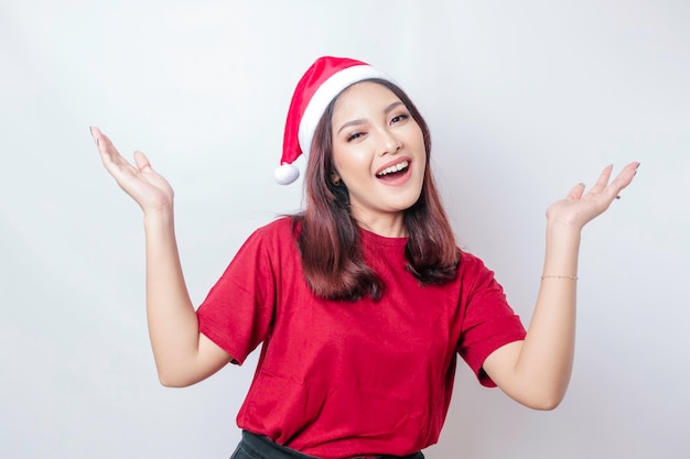 Feliz santa asiática está sorrindo e apontando para cima dela isolada por um conceito de Natal de fundo branco