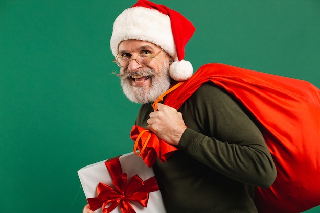 Feliz Santa Claus moderno barbudo con caja de regalo y saco rojo