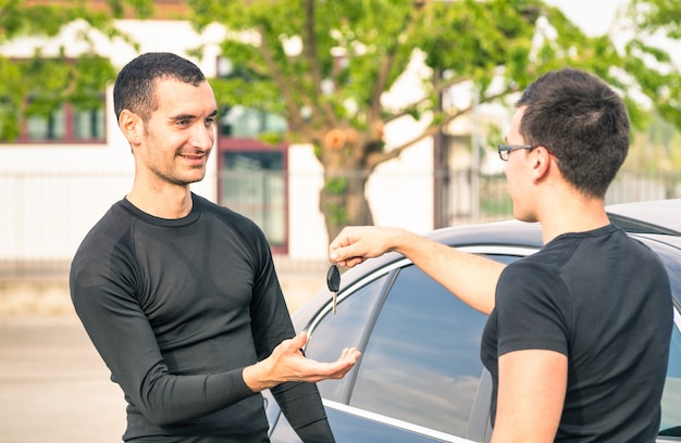 Feliz, satisfeito, homem jovem, recebendo, teclas carro, após, segunda mão, venda