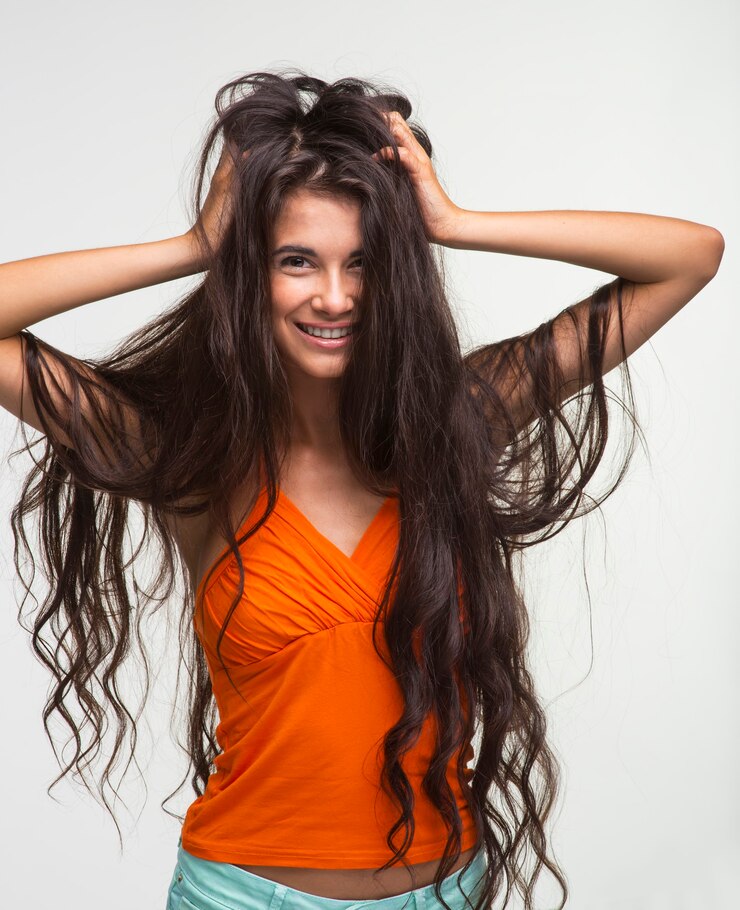 Foto feliz senhora de camisa laranja está sorrindo.
