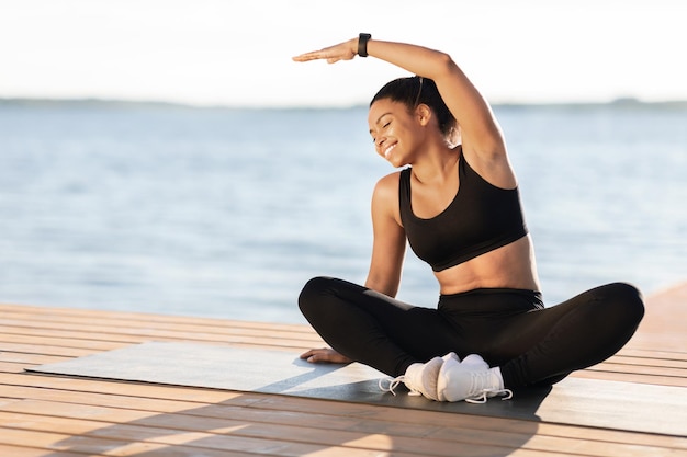 Feliz senhora negra desportiva desfrutando de seu treino ao ar livre